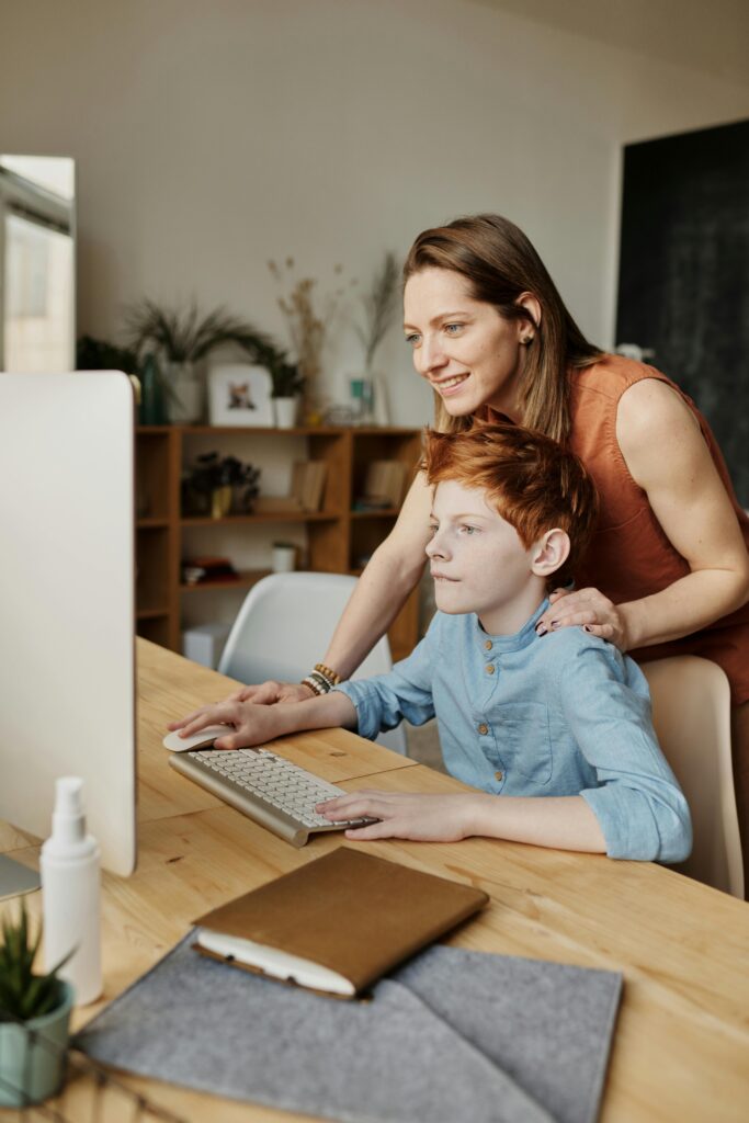 Mom and son in front of a desk computer discussing chores